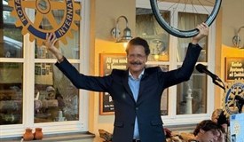 Präsident Dr. Kalus Burkhardt mit dem rotarischen Rad und einem Rad als Symbol für sein Projekt
